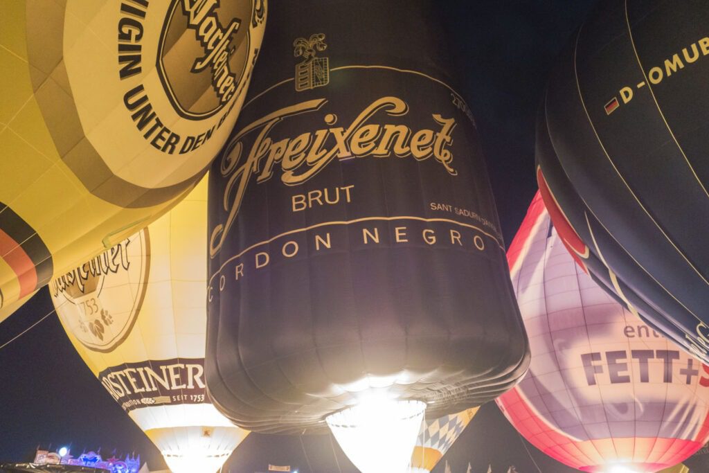 Ballone im Marketing Schwarze Freixenet Sektflasche beim Feuerwerk ballonglow