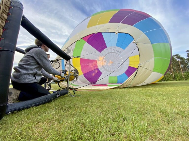 Flugschüler steht im Korb eines Heißluftballons neben dem Fluglehrer und bedient den Brenner während einer Ausbildungsfahrt Ausbildung BPL Ballonpilot Quereinsteiger Pilot